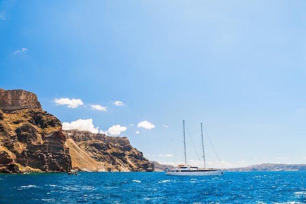 Yate blanco cerca de la isla de Santorini, Grecia. Hermoso paisaje con vista al mar.