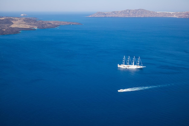 Yate y lancha rápida en mar azul. Isla de Santorini, Grecia. Viajes y vacaciones, transporte