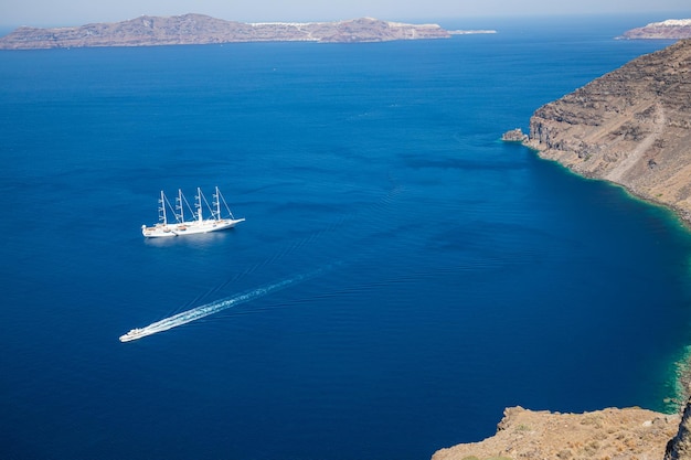 Yate y lancha rápida en mar azul. Isla de Santorini, Grecia. Viajes y vacaciones, transporte