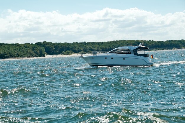 Yate de motor en el yate del océano del mar en ondas azules