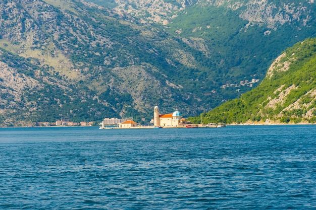 El yate navega cerca de la pintoresca isla de Gospa od Skrpela en la bahía de Boka Kotorsky.