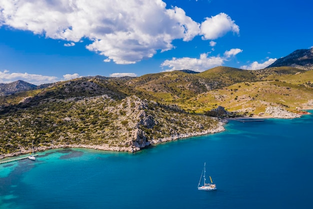 Foto yate navegando cerca de la costa rocosa en turquía vacaciones de lujo en el mar