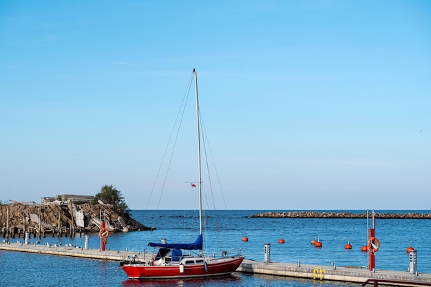 Yate en una plataforma de madera en el puerto de Engure en la costa del Mar Báltico