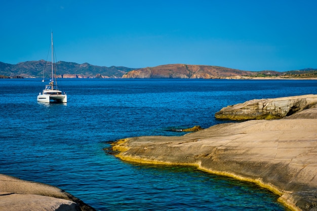 Foto yate en la playa de sarakiniko en el mar egeo, isla de milos, grecia