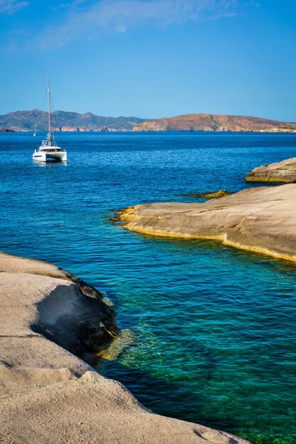 Foto yate en la playa de sarakiniko en el mar egeo, isla de milos, grecia