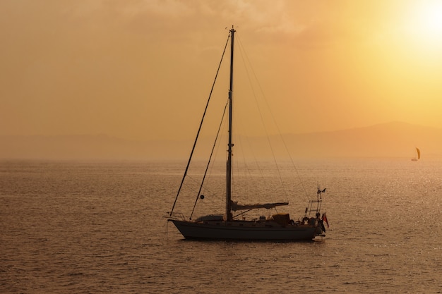 Yate de vela del atardecer, teñido en tonos cálidos