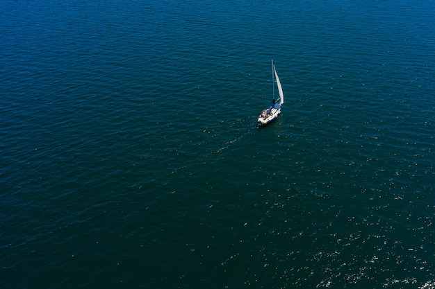 Yate de vela blanco solitario en el mar, vista aérea, tiro con drones