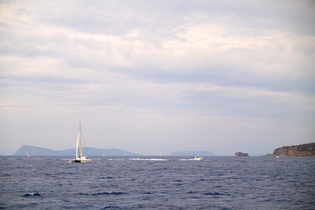 Yate de vela catamarán anclado en el agua de mar azul profundo