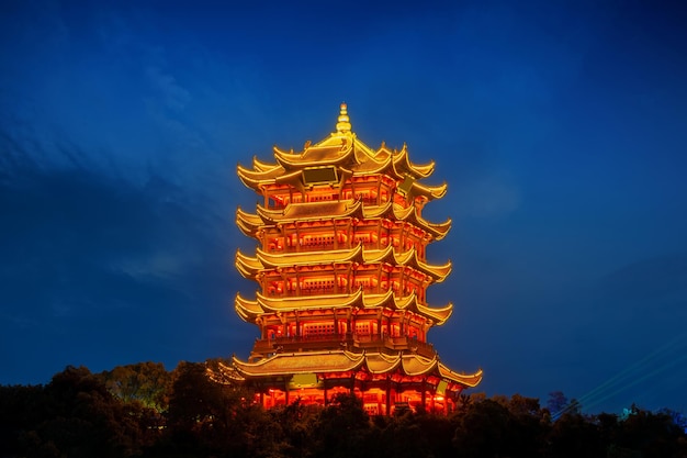 Yellow Crane Tower in der Dämmerung, der traditionelle chinesische Mehrstöckerturm auf dem Sheshan Snake Hill in Wuhan, Hubei, China