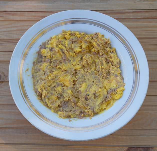 Foto yema de huevo mezclada con receta de pescado enlatado en el proceso de cocción