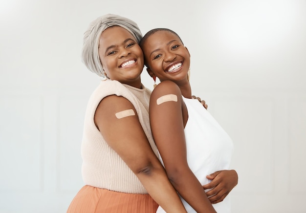 Yeso de vacuna y retrato de mujeres negras después de una inyección como cura médica aislada en un fondo blanco Bienestar de la salud y amigos felices en un hospital o clínica para medicina juntos