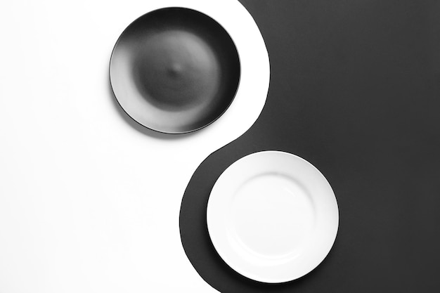 Yin-Yang-Symbol mit Platten auf farbigem Hintergrund flach gelegt Zen-Konzept