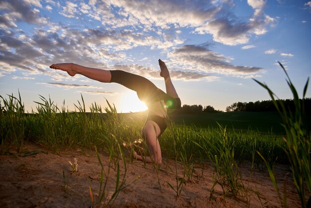 yoga al aire libre en un campo verde durante el atardecer