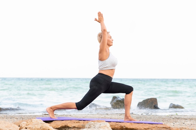Yoga alongamento ao ar livre. Vista lateral de mulher praticando ioga