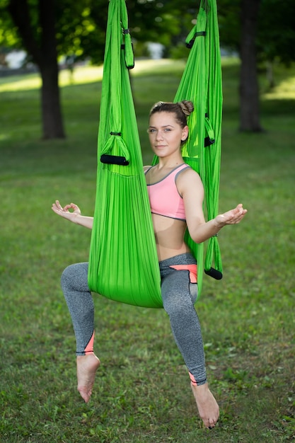 Yoga anti-gravedad, mujer haciendo ejercicios de yoga en el parque