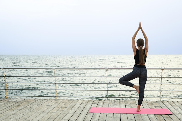 Yoga ao ar livre com jovem conceito de saúde e cuidados com o corpo