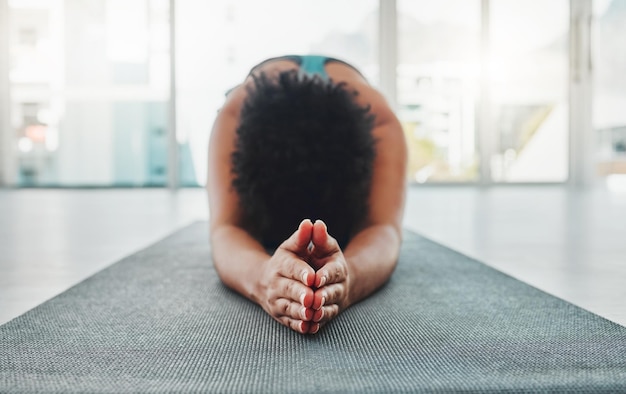 Yoga-Armdehnung und Gebetshände einer schwarzen Frau in einem Fitnessstudio zum Entspannen und Trainieren Pilates-Friedens- und Meditationstraining eines Athleten in Gebetshaltung auf dem Boden, der sich von der Dehnung ruhig fühlt