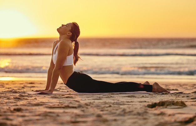 Yoga Cobra Stretch und Frau am Strand für Fitness, Gesundheit und Wellness Sunset Zen Chakra und weiblicher Yogi, der Pilates-Meditation und Training praktiziert, Stretching und Bewegung im Freien an der Küste