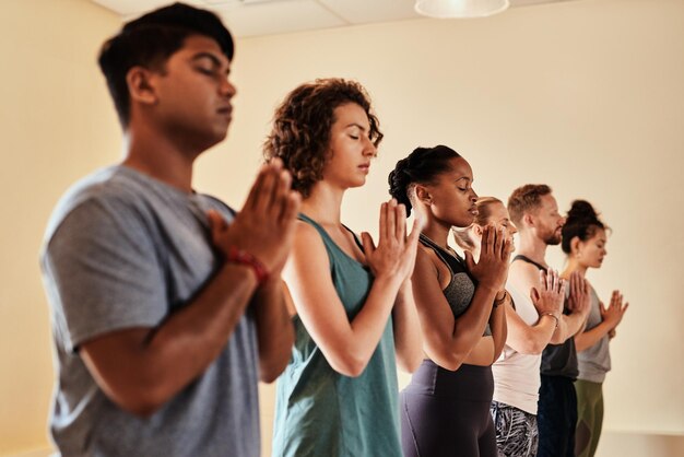 Yoga é um trabalho de coração Foto de um grupo de jovens homens e mulheres meditando em uma aula de ioga