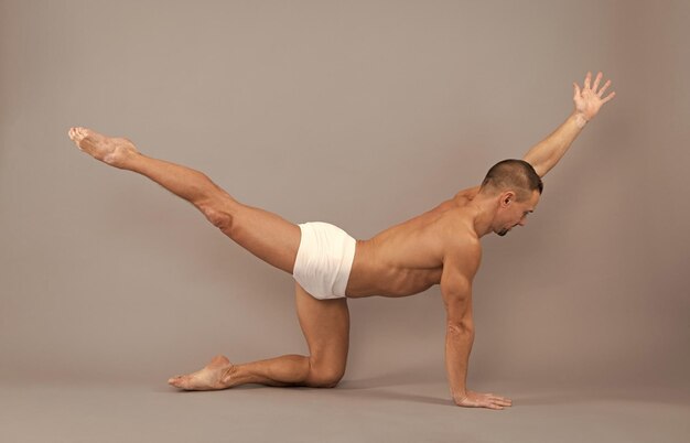 Foto yoga para el equilibrio y la estabilidad chico en forma hacer pose de mesa de equilibrio entrenamiento y entrenamiento de equilibrio dandayamana bharmanasana fitness y deporte actividad gimnástica