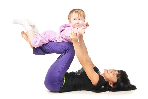 Yoga für Frau und Kind. Mutter mit dem Baby macht Übungen