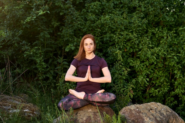 Yoga im Natürlichen. Yoga einer attraktiven Frau. Spirituelles und emotionales Konzept. Lebensporträt im Freien.