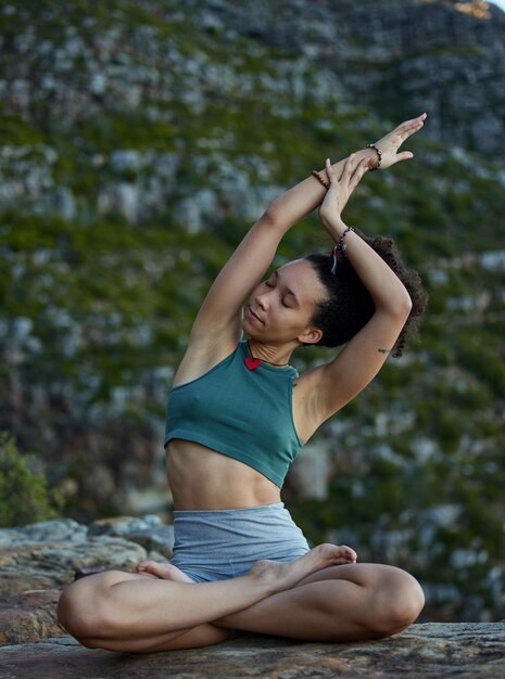 Foto yoga lässt sie die dinge anders sehen. aufnahme einer jungen frau, die in den bergen yoga praktiziert