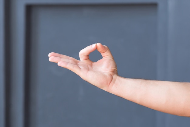 Yoga mano mudra en pared gris