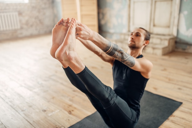 Yoga masculino en clase, formación de prensa