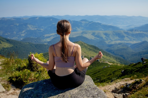 Yoga, meditação. Mulher equilibrada, praticando meditação e ioga de energia zen nas montanhas. Garota fazendo esporte de exercício de aptidão ao ar livre na manhã. Conceito de estilo de vida saudável.