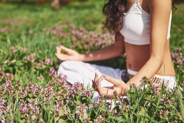 Yoga-Meditation in einem Park im Gras ist eine gesunde Frau in Ruhe.