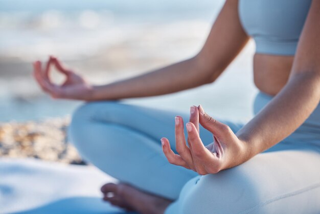 Yoga-Meditation und Zen-Hände der Frau am Strand für Fitnessübungen und Achtsamkeit in der Natur, Wellness und Frieden im Freien Meditieren Sie mit dem Handzeichen oder der Lotus-Pose einer spirituellen und heilenden Person am Meer