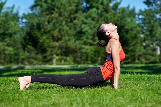 Yoga. Mujer joven practicando yoga meditación en la naturaleza en el parque. Concepto de estilo de vida saludable.