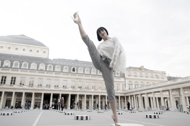 Yoga, pilates, fitness, deporte en parís, francia. Pierna partida mujer en cuadrado. Moda, belleza, estilo, estilo de vida. Chica con zapatos de tacón, ropa de moda. Vacaciones, concepto de viaje.