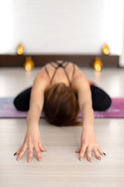 Foto yoga practicante de la mujer joven que estira en gimnasio