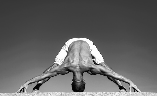 Yoga-Praxis hilft, Harmonie und Gleichgewicht zu finden Mann, der Yoga praktiziert, blauer Himmelshintergrund Erreichter Seelenfrieden Meditations- und Yoga-Konzept Yoga hilft, Gleichgewicht zu finden Üben Sie Asana im Freien