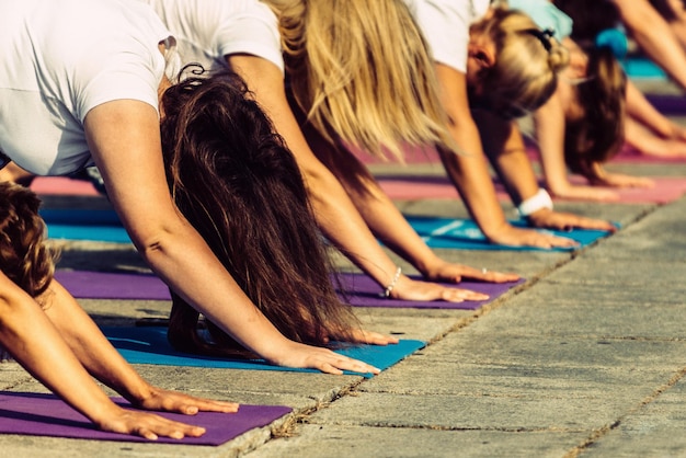 Yoga-Tagesgruppe von Menschen in herabschauender Hundehaltung