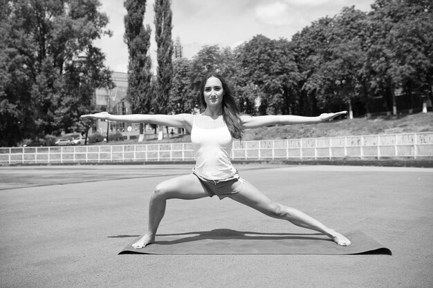 Yoga-Trainer Pilates-Fitness und Gewichtsverlust Dehnungsübungen Training im Freien Gesunder Körper der Frau praktiziert Yoga im Freien Naturhintergrund Mädchen-Stretching-Training Stretching-Muskeln