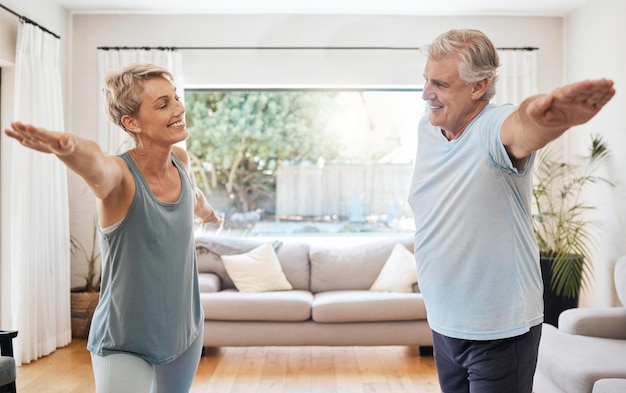 Yoga-Wellness zu Hause Senioren-Paar dehnt Muskeln im Wohnzimmer und Ruhestand-Wellness in Australien Fitnesstraining Körper zusammen gesundes Training in der Lounge und glücklich entspannen in Übungspose