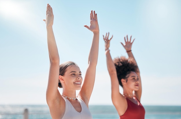 Yoga Zen und Strand mit Freundinnen im Freien zusammen in der Natur für Wellness-Training Trainieren Sie Chakra oder Fitness mit einem weiblichen Yogi und einer Freundin draußen für ein mentales Gesundheitstraining am Meer