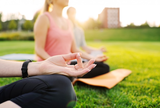 Yogagruppe auf dem Hintergrund des grünen Grases