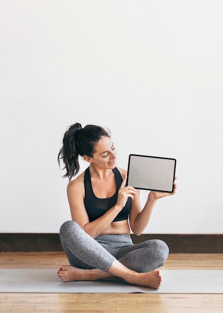 Yogalehrer, der ein digitales Tablet-Handy-Hintergrundbild zeigt