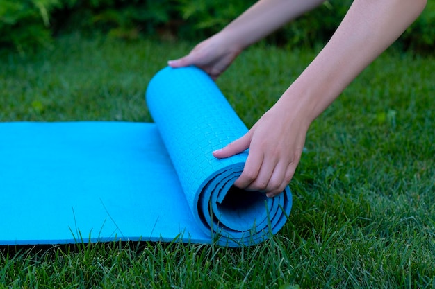 yogamatte blaue weibliche hände entspannen sich auf grünem gras