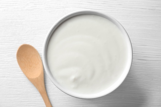 Yoghurt sabroso en un plato en una mesa de madera