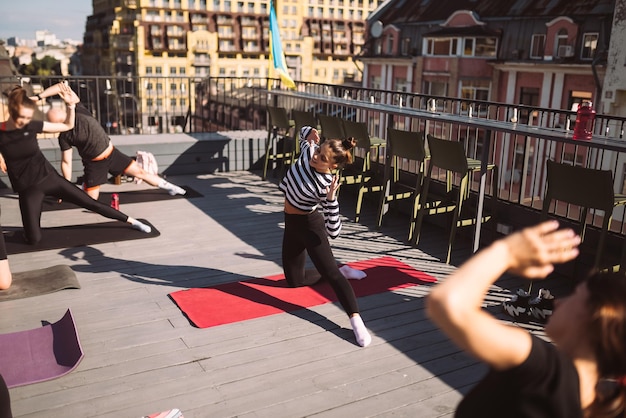 Yogi-Frau und vielfältige Gruppe sportlicher Menschen, die Yoga praktizieren