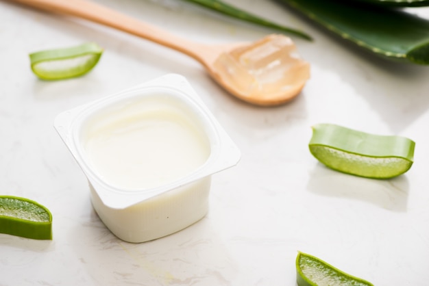 Yogur de aloe vera con hojas frescas sobre una mesa de madera