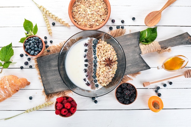 Yogur con avena y arándanos y moras Semillas de chía Desayuno Sobre un fondo de madera Vista superior Espacio libre para texto