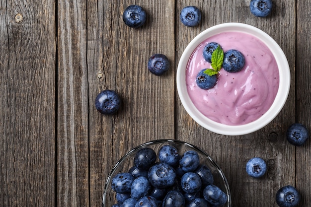 Yogur casero con arándanos frescos sobre una madera