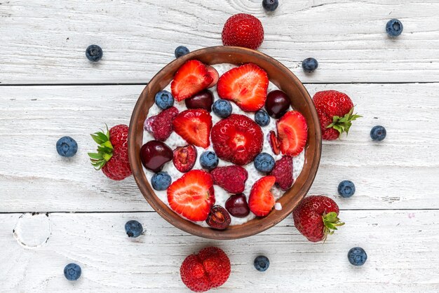 Yogur casero de bayas o budín de chía con frambuesas frescas, fresas, cerezas y arándanos en un tazón