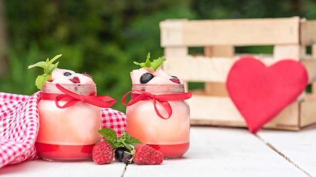 Yogur casero para el desayuno en pequeños frascos de vidrio con frutos rojos.